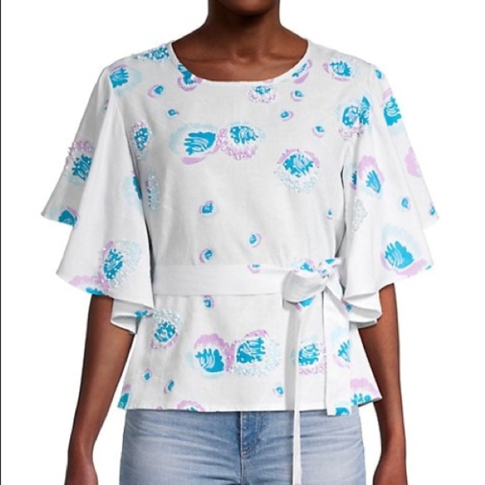 This printed top features embellishments and waist self-tie.